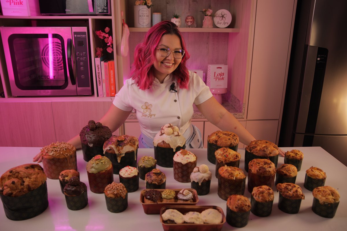 Chef Laíse Lopes atrás da mesa com a produção inteira de panetones